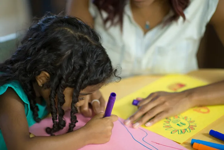 little girl and mother coloring a picture together